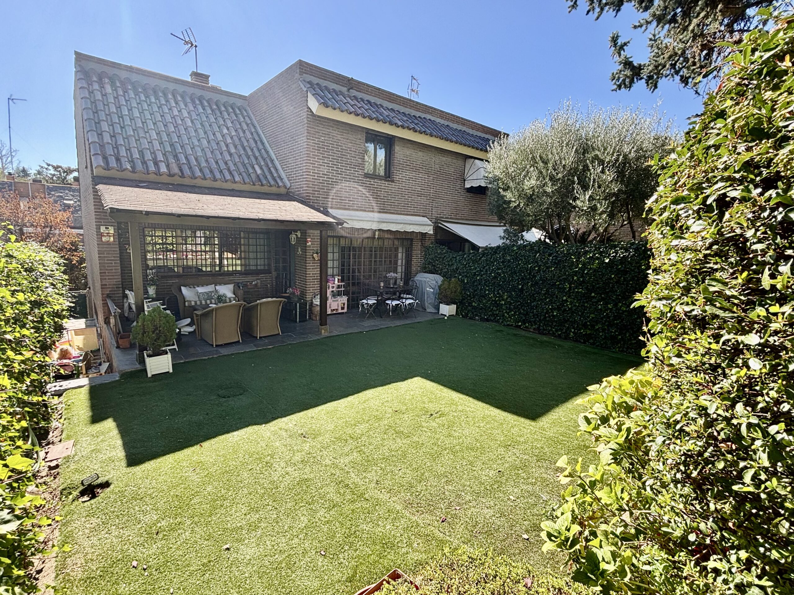 Jardín privado con barbacoa y acceso a la piscina en chalet de La Moraleja.