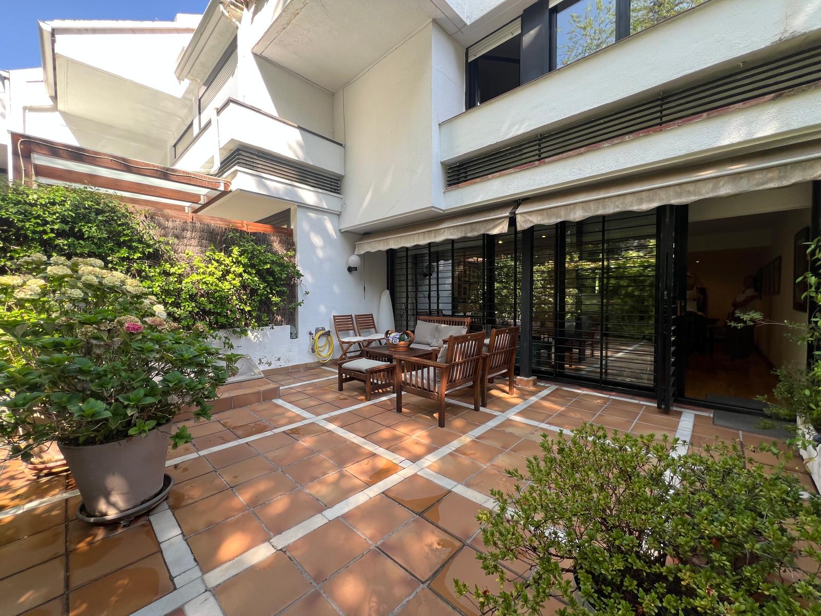 Terraza exterior y jardín privado de chalet adosado con orientación sur en El Soto de La Moraleja.